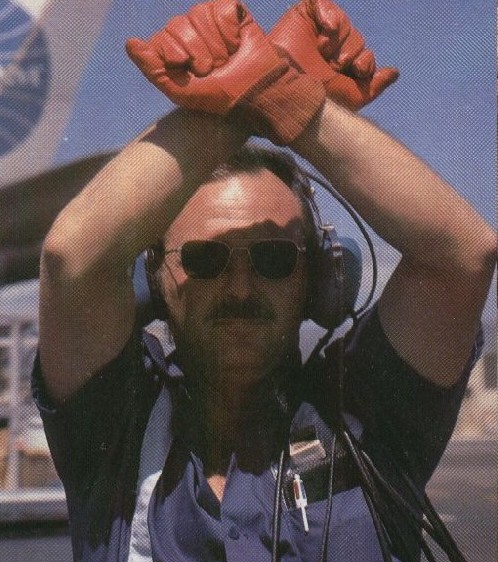 1977 A Pan Am mechanic parks an airplane wearing a pair of bright red gloves.